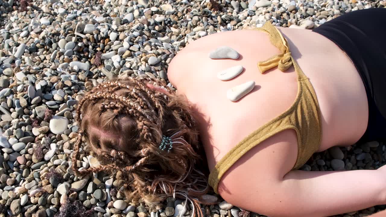 mujer recibiendo masaje de piedras en una playa