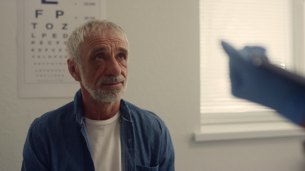 초상화: 노인 남자가 병원에서 치료사를 방문합니다. 여성 의사가 태블릿에 타이핑하고 있습니다.