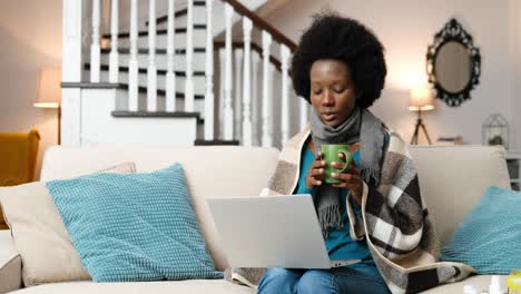 portrait of sickwoman videochatting and drinking tea in room