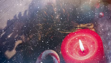 candles and christmas decoration outside a window combined with falling snow