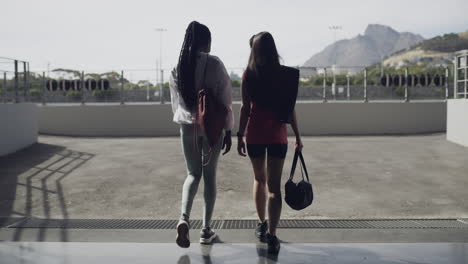 two women walking away from a stadium