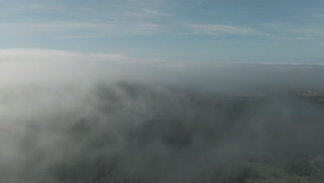 Aerial-view-of-forest-through-transparent-clouds-above-Magdalen-Islands-in-Quebec