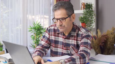 focused businessman doing research typing on laptop. home office.