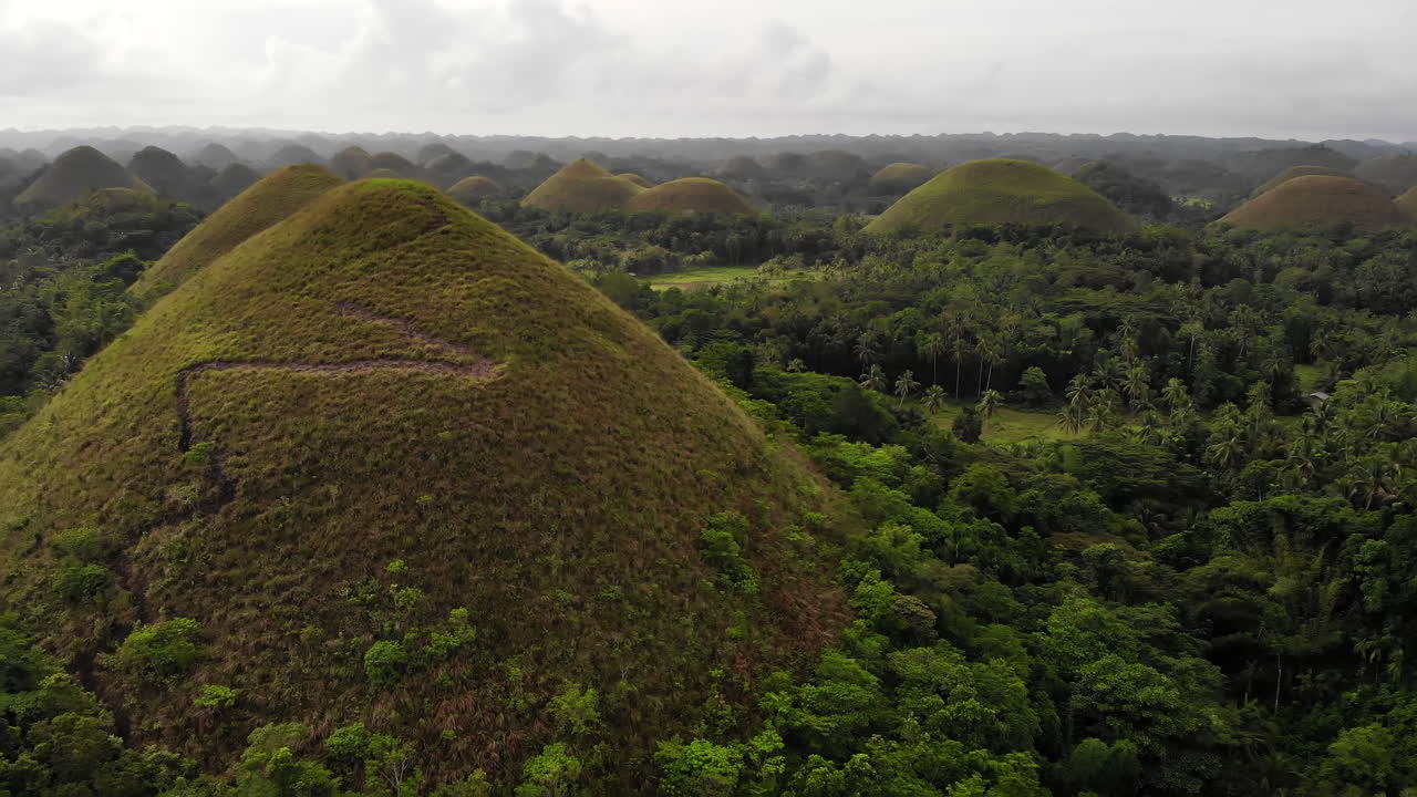 volando rápido hacia una de las colinas en las colinas de chocolate en bohol, filipinas