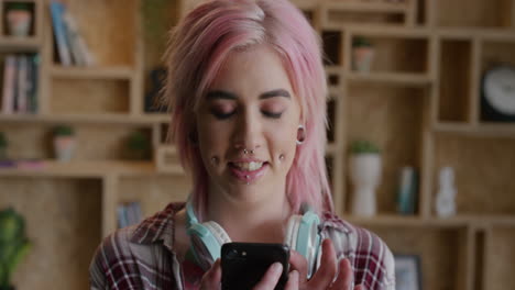 retrato de una hermosa mujer punk usando un teléfono inteligente enviando mensajes de texto navegando en línea disfrutando de la comunicación móvil independiente mujer funky cabello rosa cámara lenta