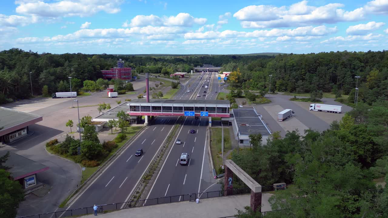 Dreilinden Checkpoint Bravo border crossing. German freeway traffic on sunny day with blue sky. Gorgeous aerial view flight drone shot footage from above