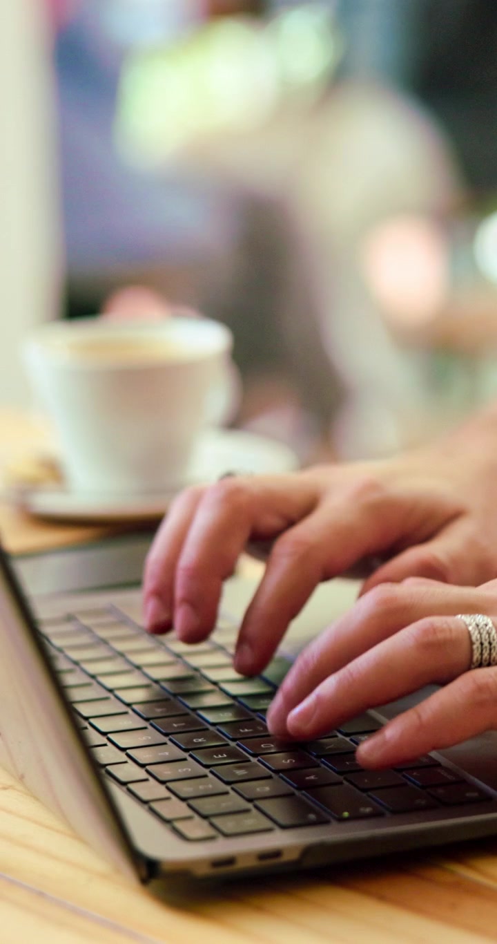 Persona che scrive sul portatile in un caffè