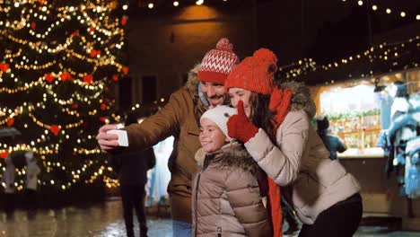 young happy family taking selfies at christmas.young happy family of four taking selfies at christmas, slow motion. winter holidays and new year celebration concept