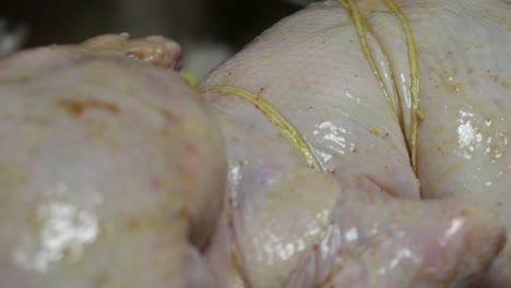 cerca, pan a la derecha de pollo crudo atado a la horquilla