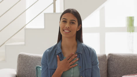 Video-of-happy-biracial-woman-sitting-on-sofa-and-having-video-call