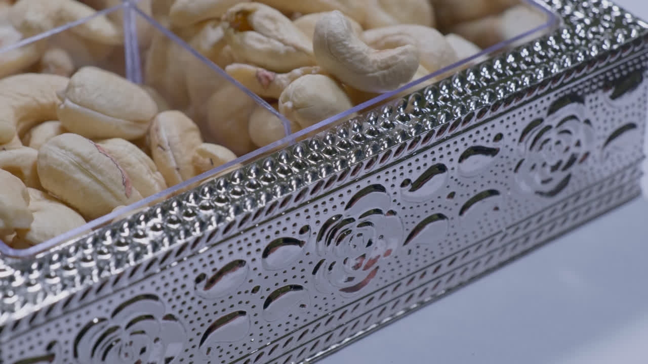 cashew nuts in a fancy silver plastic box, 4k, close up, push in shot