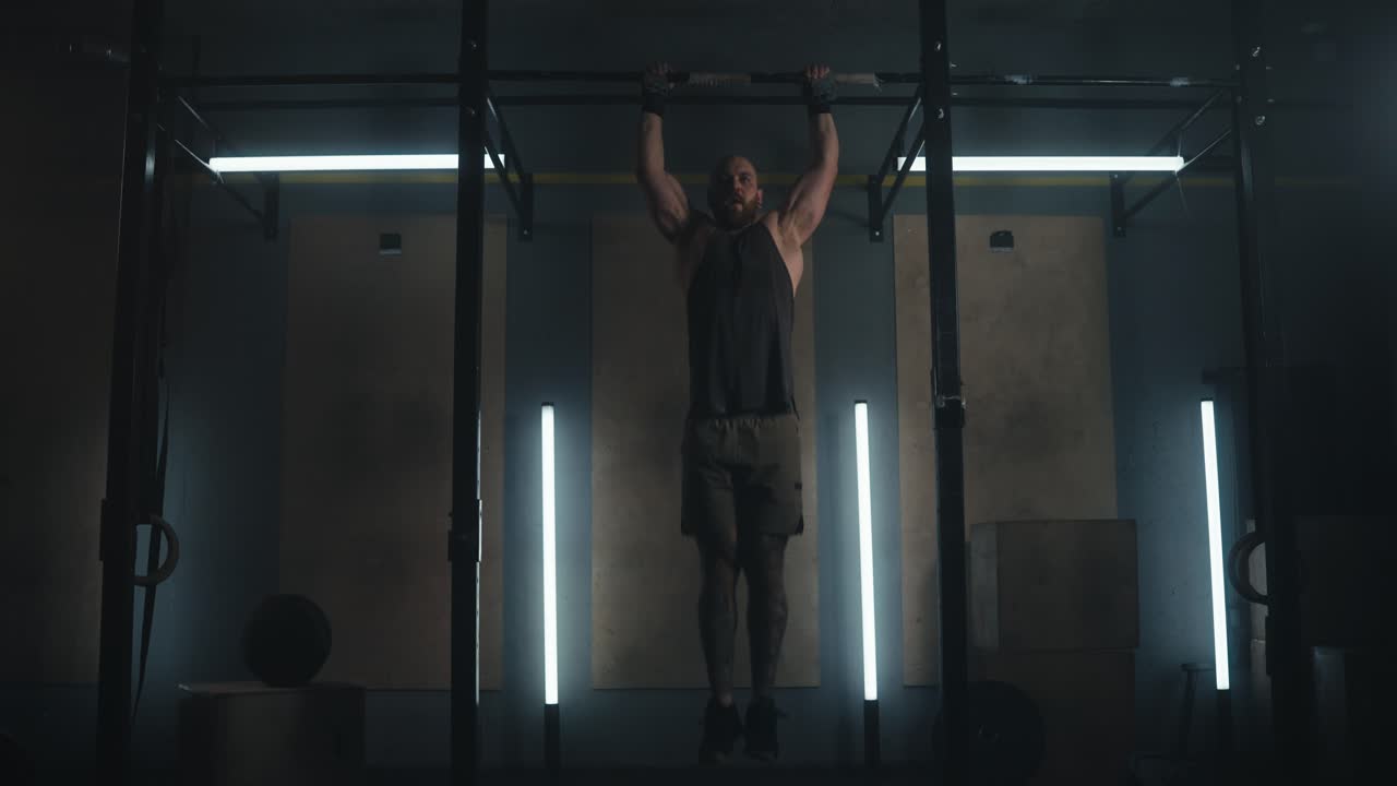 hombre realizando pull-ups en un gimnasio