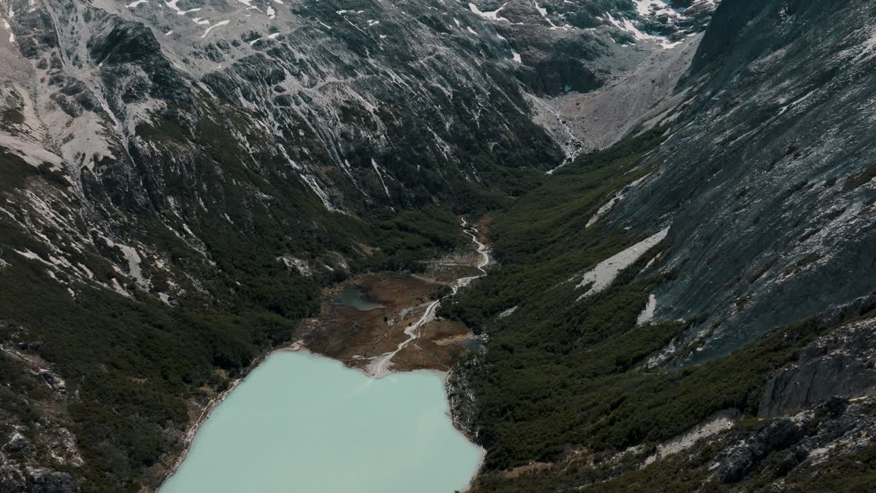 lago de agua glaciar turquesa en la montaña - laguna esmeralda, ushuaia, provincia de tierra del fuego, argentina - toma aérea de avión no tripulado