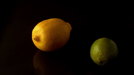 limón y lima girando en la superficie negra