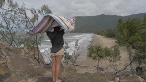 Junge-Frau-Mit-Handtuch-Weht-In-Der-Meeresbrise-Am-Strand-In-Qld,-Australien