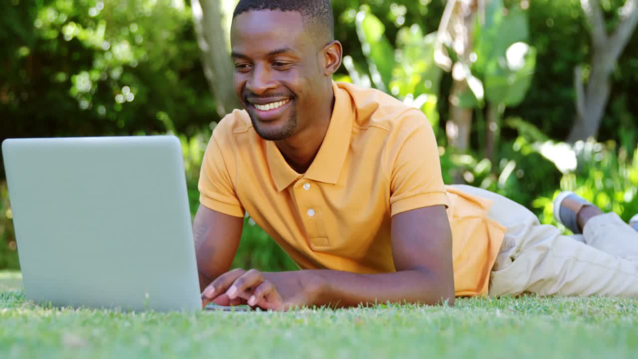 Portrait of man lying and using a laptop