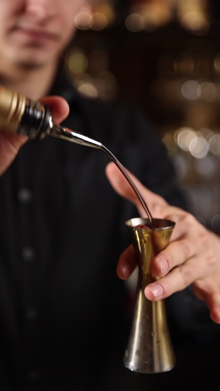 Barman professionista che versa liquido in un jigger