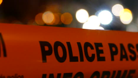 closeup of the word police written on bright orange crime tape