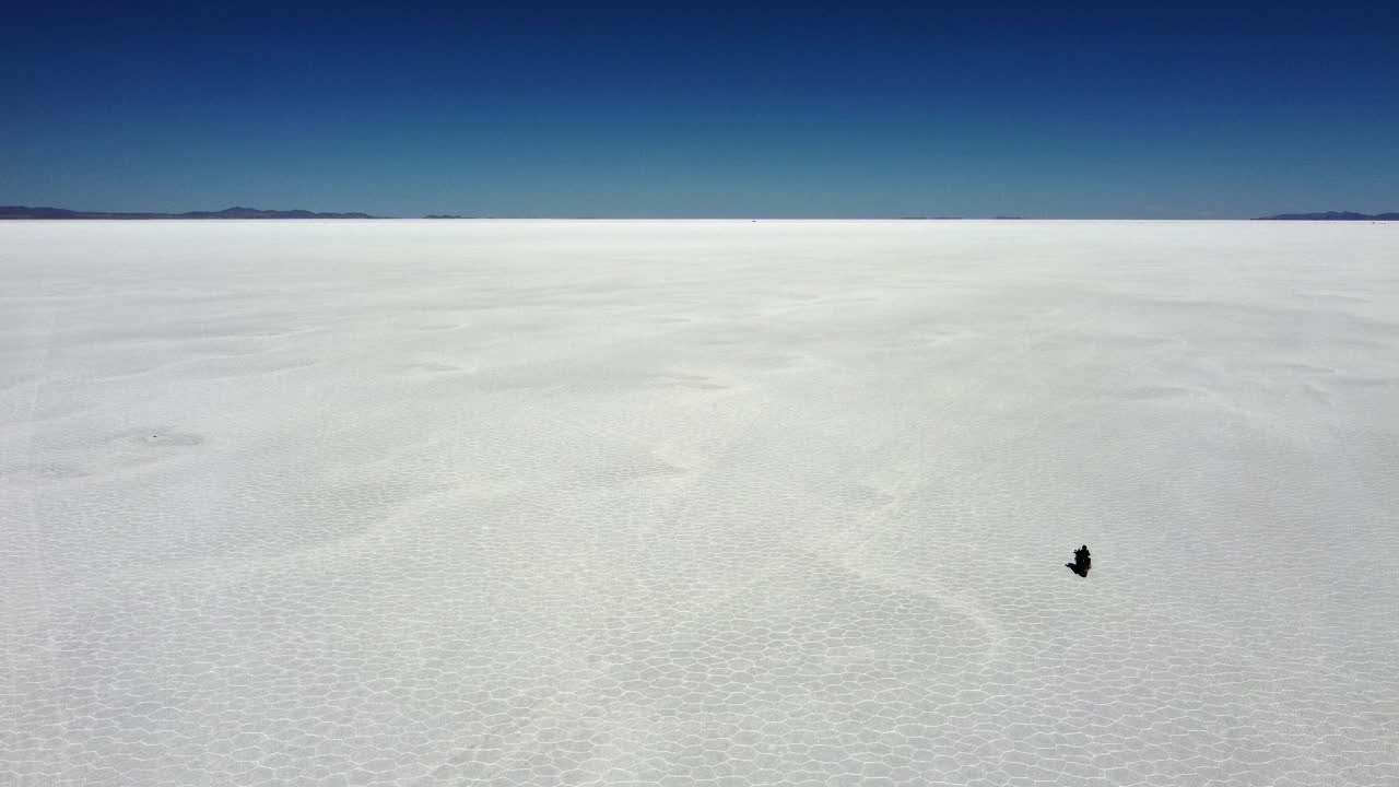 모터사이클이 스 패턴으로 멀리 달리는 우유니 소금 평평한 호수
