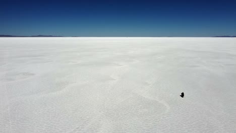 Motorcycle-rides-into-distance-on-hex-pattern-Uyuni-Salt-Flat-lake