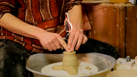 professional potter shaping mug in pottery workshop