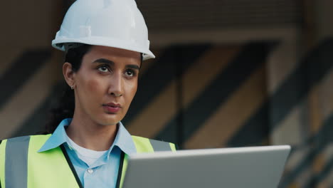 female engineer working on a laptop at a construction site