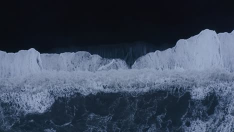 Aerial-straight-down-shot-of-Vi-kurfjara-Beach-with-black-sand-and-basalt-rocks-and-over-flooding-Atlantic-ocean-waves-in-Iceland