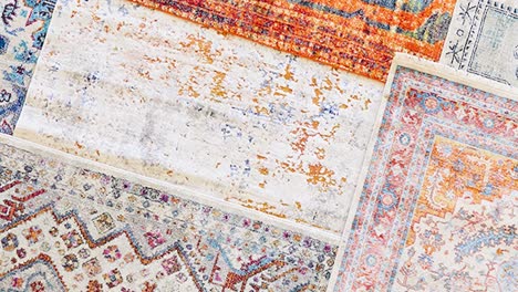 camera pans along lined-up rug swatches with varied patterns