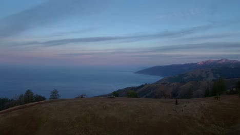 Flying-over-a-truck-on-a-dirt-road-above-the-California-coast-at-sunrise