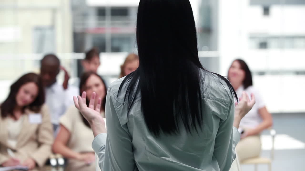 갈색 사업가 여성이 사업가들과 이야기하고 있습니다.