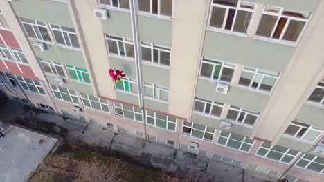 rope climber dressed as santa climbing down an exterior wall of a hospital