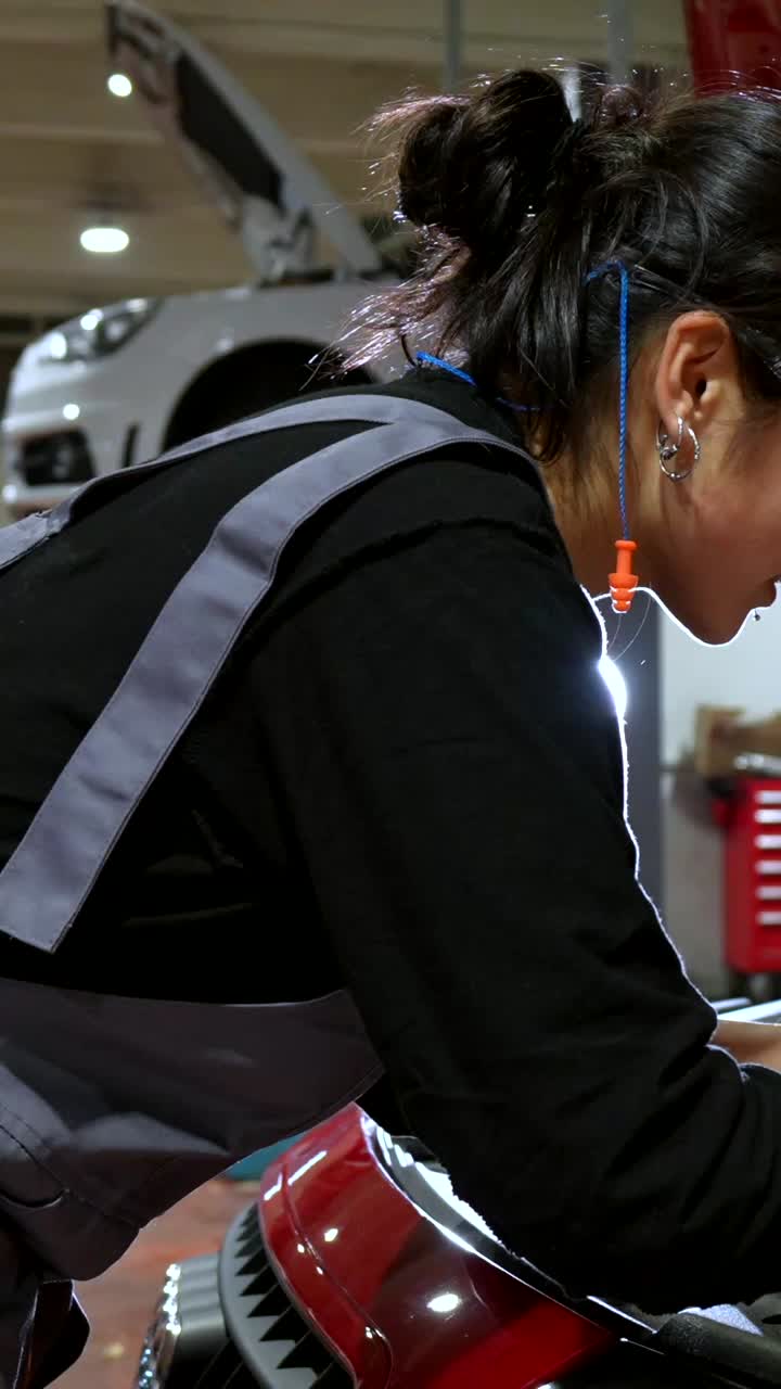 Female mechanic using laptop for car repair