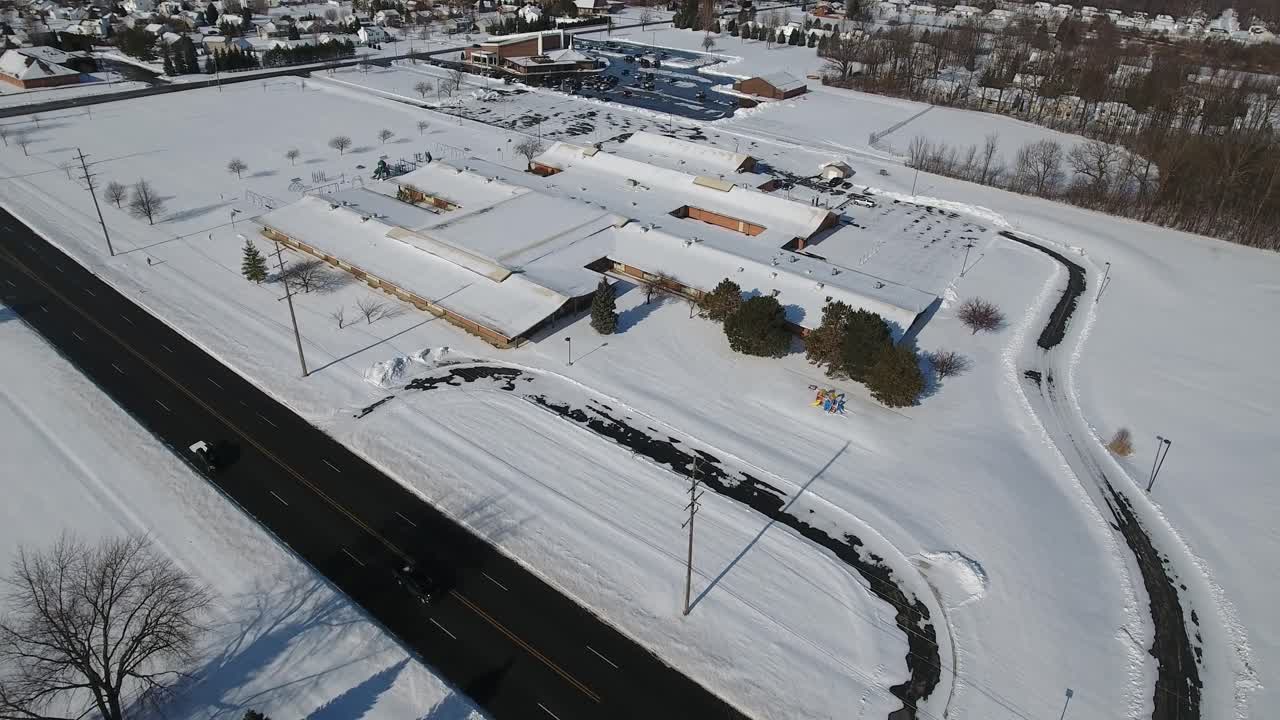 A slow moving forward winter establishing shot of a suburb middle school.