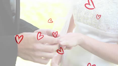 animation of red hearts over caucasian couple wearing rings