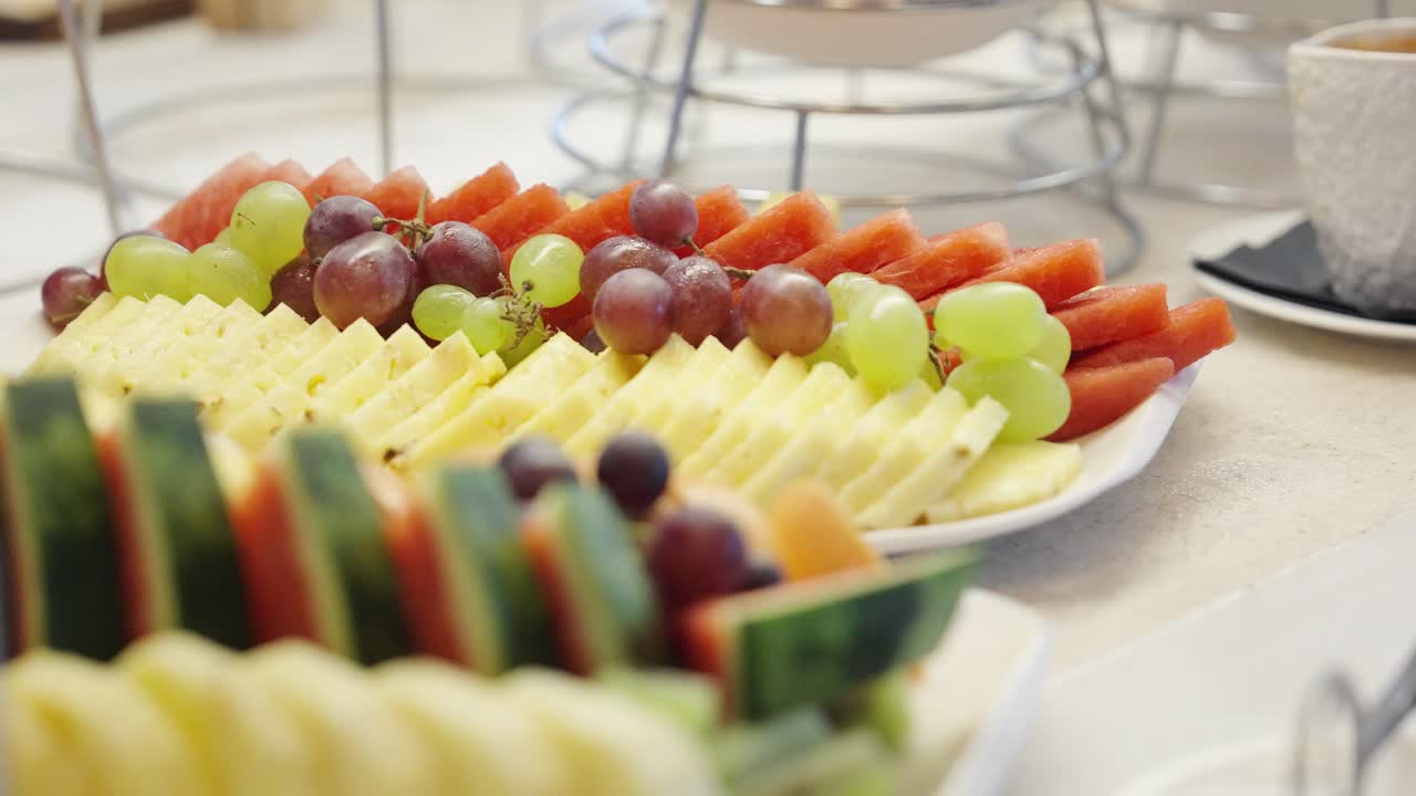 Delizioso piatto di frutta nel buffet della colazione in hotel, ripresa in movimento.