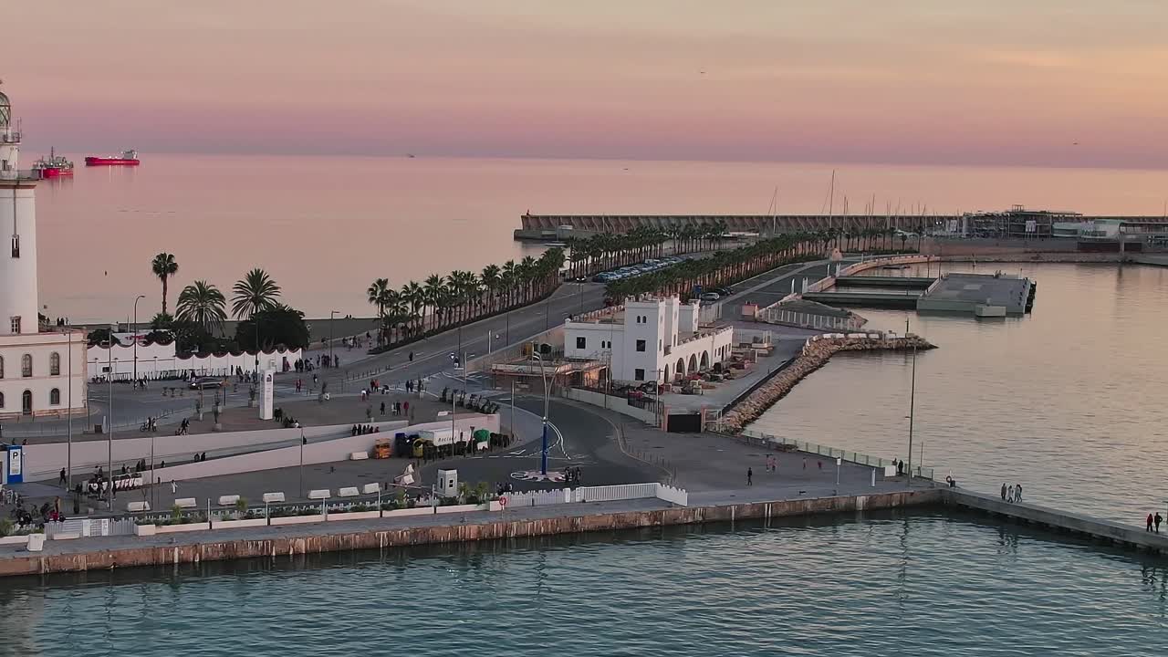 Tramonto sul porto di Malaga, Spagna, con faro e palme