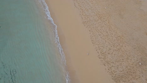 turquoise waves gently lap over sand formations at cala pregonda