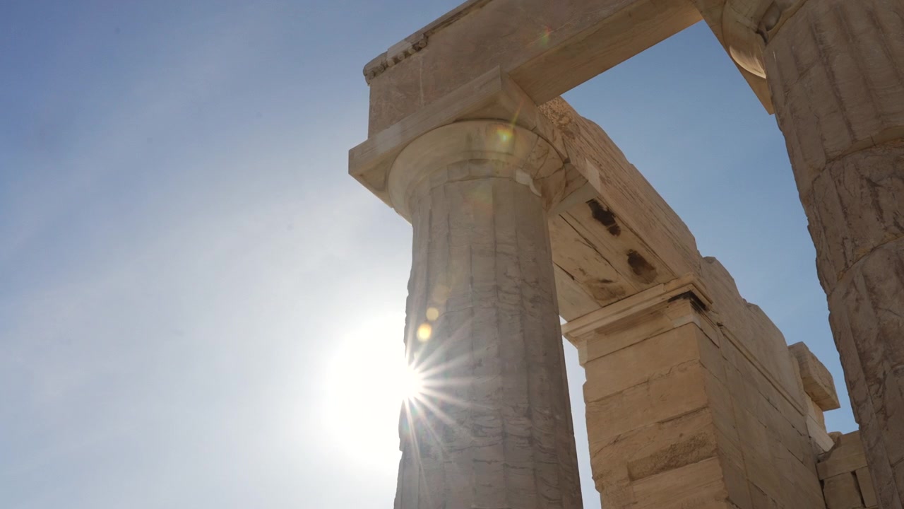 Sun shining through Acropolis Parthenon pillar in Athens, Greece