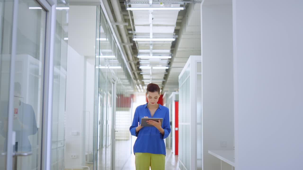 mujer de pie con la tableta en una oficina moderna