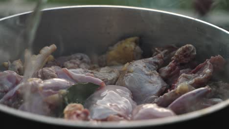 adding wine to chicken in large cooking pot