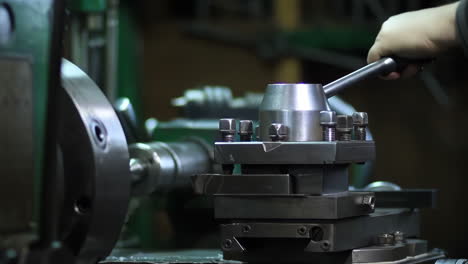 skilled professional machinist working intently on a large industry in heavy metal factory workshop with large machines