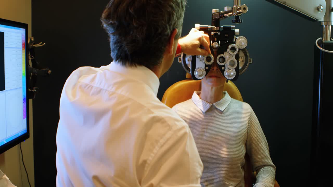 Optometrist examining patient eyes with phoropter 4k