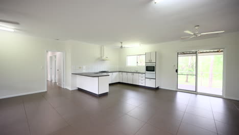 empty open planned interior of property with lounge room kitchen dining area vacant built on wooden floor boards and verandah access