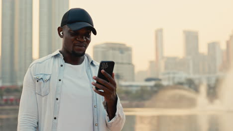 man using a smartphone in a city park
