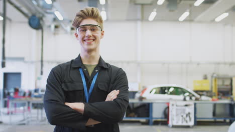 Porträt-Eines-Männlichen-Studenten-Mit-Schutzbrille,-Der-An-Der-Hochschule-Eine-Kfz-Mechaniker-Ausbildung-Macht