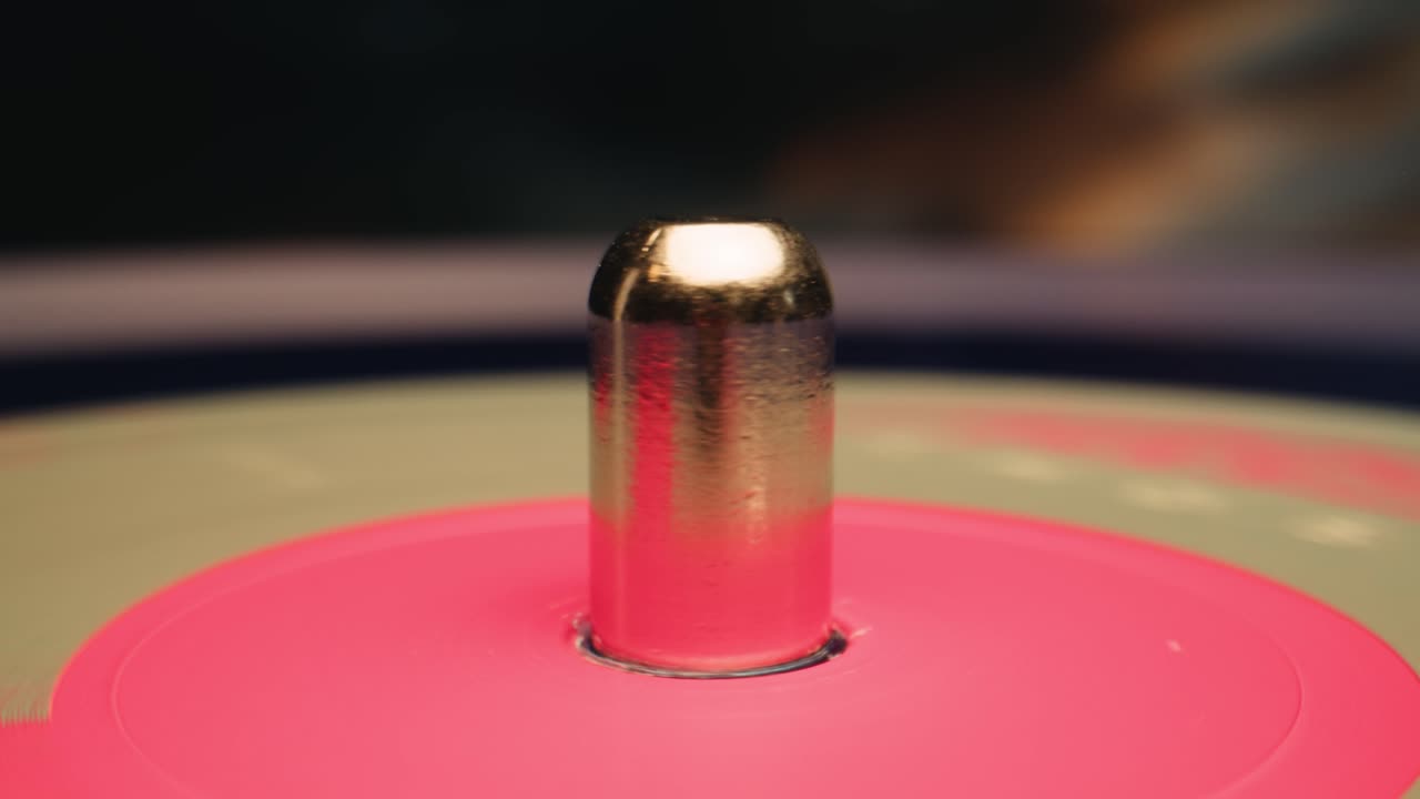 Close-up of a Vinyl Record Spinning on a Turntable with Pink Adapter
