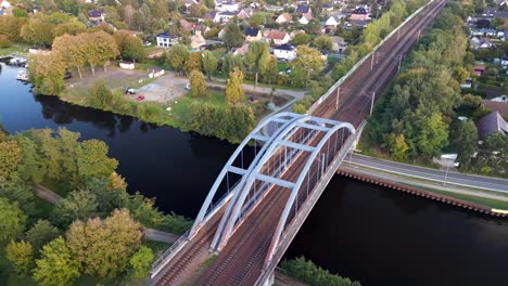Perfect aerial view flight panorama orbit drone
Railway bridge over river, Brieselang in brandenburg Germany at summer golden hour 2022