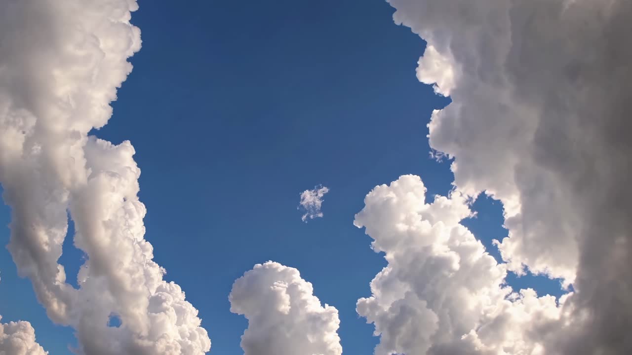 Aerial video view of dramatic clouds framing a bright blue sky