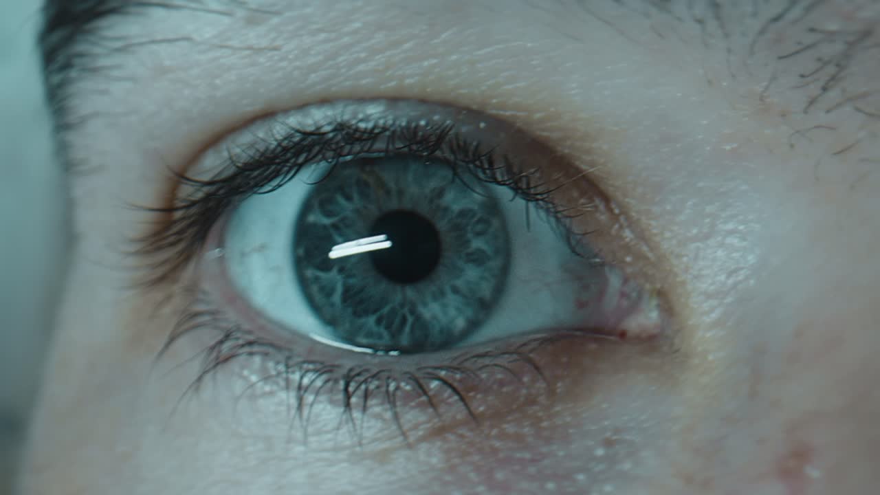 ojo caucásico azul parpadeando en tiempo real, primer plano extremo