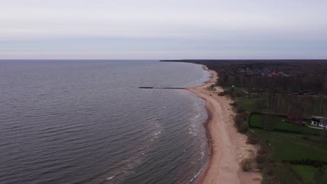 sandy coastline and breakwater in aerial drone view